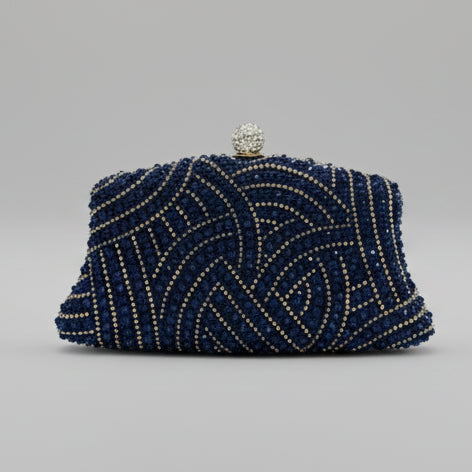 Navy blue beaded clutch bag on a marble surface with a neutral background