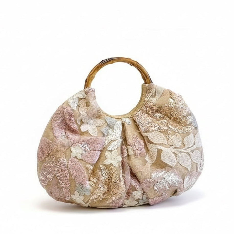 Floral patterned handbag with a tortoiseshell handle on a white background