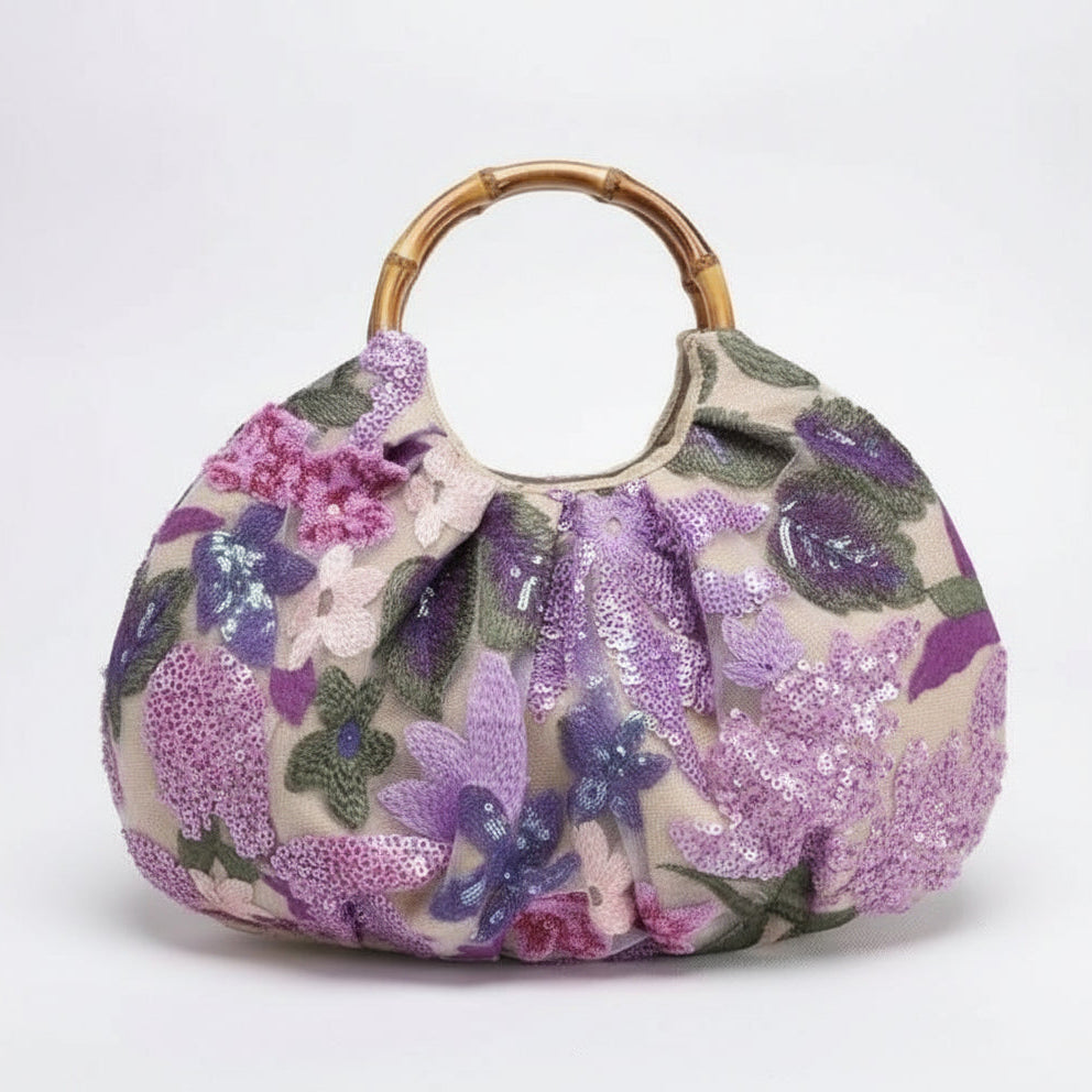 Floral patterned handbag with a bamboo handle on a white background