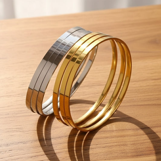 Gold and silver bangles on a wooden box with white interior